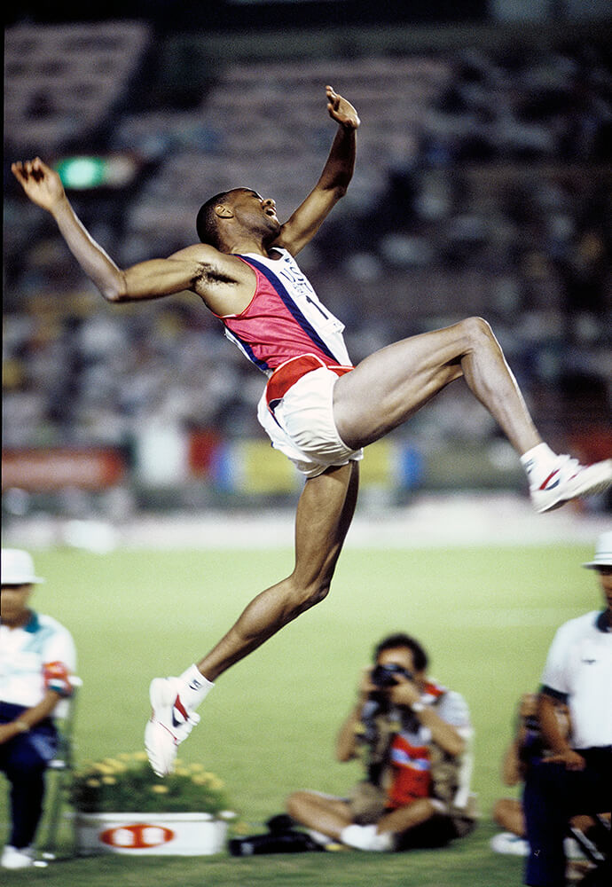 Salto de longitud de Mike Powell (USA), fotografía deportiva por Miguelez Team